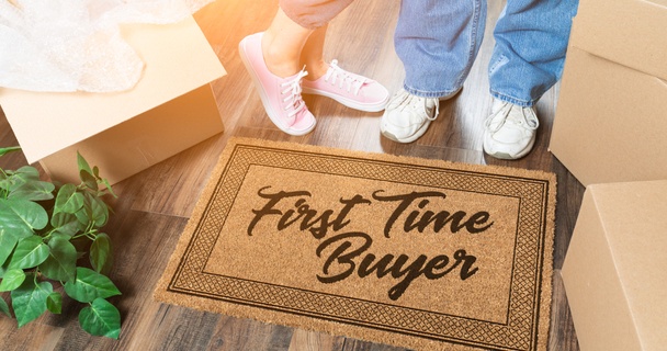 couple standing on first time buyer doormat