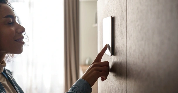 Woman using smart home device on the wall