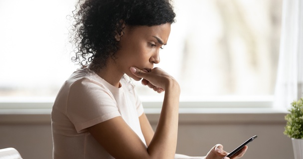 worried woman looking at mobile phone