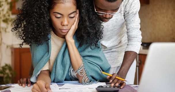 worried couple looking at bills