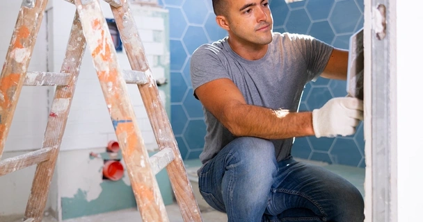 man tiling a bathroom