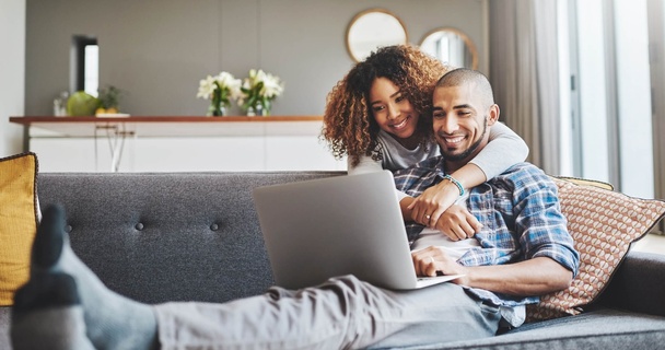 couple on sofa looking at laptop