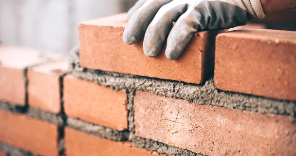 Close up of a bricklayer layering bricks on a construction site