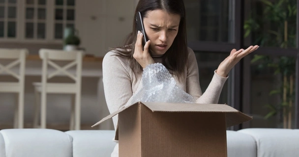 woman on the phone with a damaged parcel