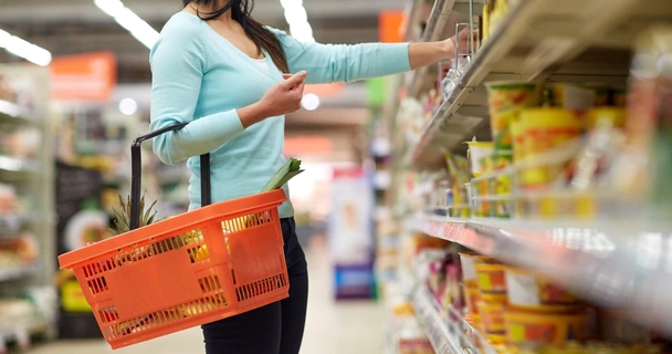 woman in supermarket holding a shopping basket