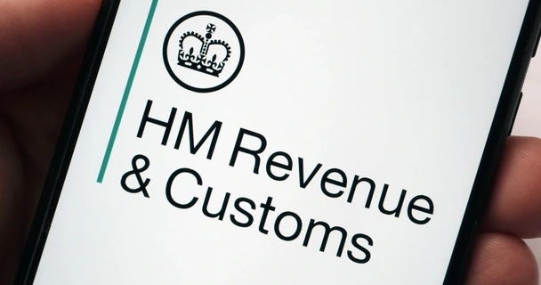 Hand holding a mobile phone with HM Revenue & Customs on the screen