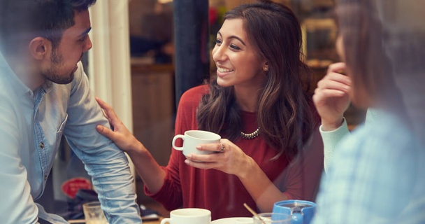 A woman enjoying a hot drink with friends.