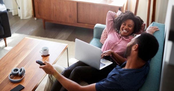 Couple in bright apartment watching TV together