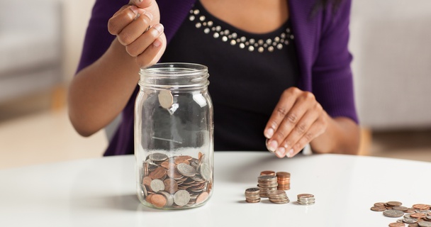 women putting money in a jar