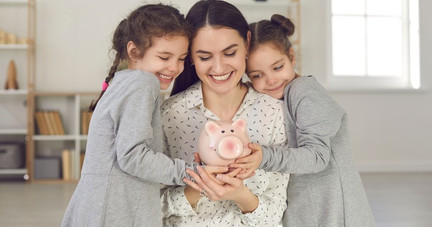 Mum holding money box with her two children.