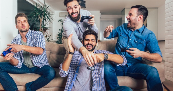 men playing video games on sofa