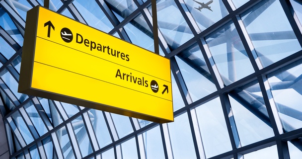 Airport terminal sign displaying directions to departures and arrivals