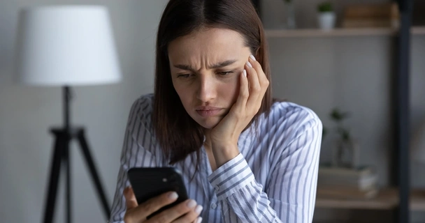 Woman looking at her smartphone, worried