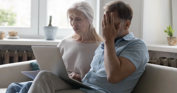 Pensioners at laptop looking upset