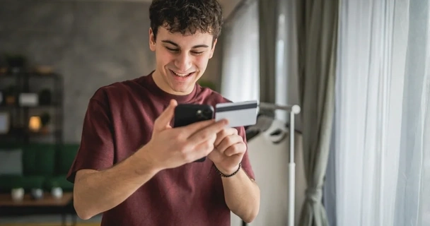 Young man with a credit card in his hand and a mobile phone