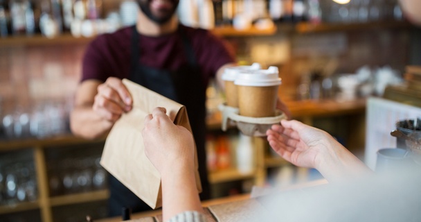 person buying takeaway coffee from server