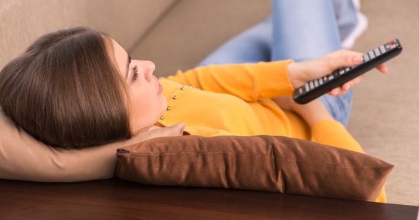 Woman lay on the couch watching TV