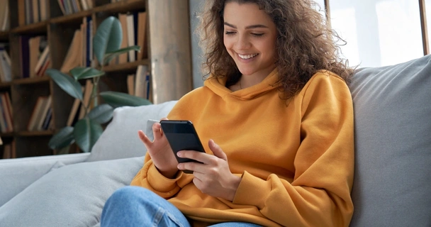 Woman smiling whilst looking at her mobile