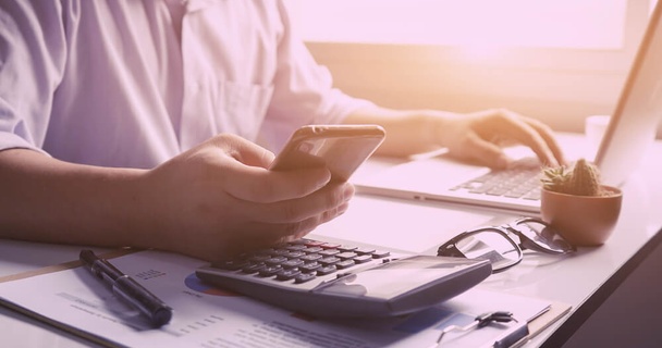 Person at laptop with a calculator