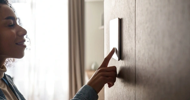 Woman using smart home device on the wall