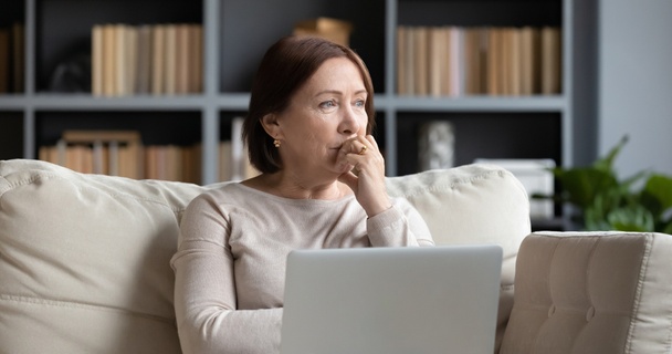 Woman using a laptop with a concerned expression