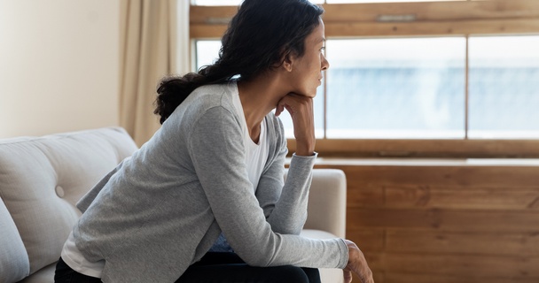 Woman sat by window thinking