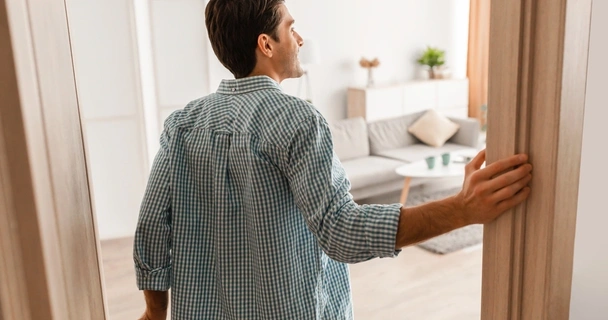 Man opening door to his living room