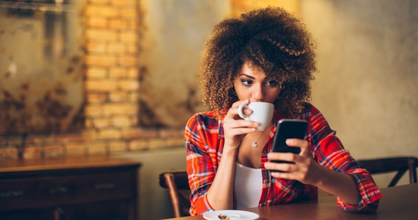 woman drinking coffee on phone