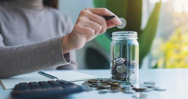 woman putting coins in jar
