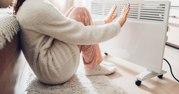 woman warming herself up by radiator