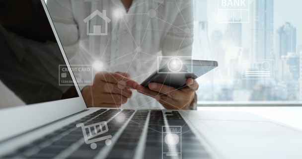 Person on phone by laptop