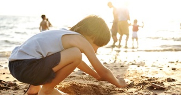 child playing in the sand on the beach