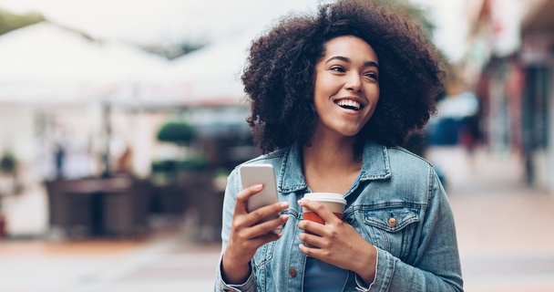 Woman holding a coffee and mobile phone