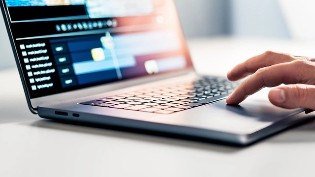 A hand touches the trackpad of a laptop. Editing software is on the screen.