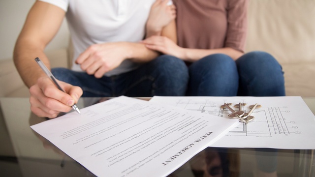 Couple signing tenancy agreement