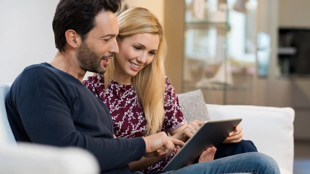 happy couple looking at laptop