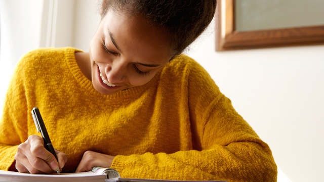 happy woman writing in notepad