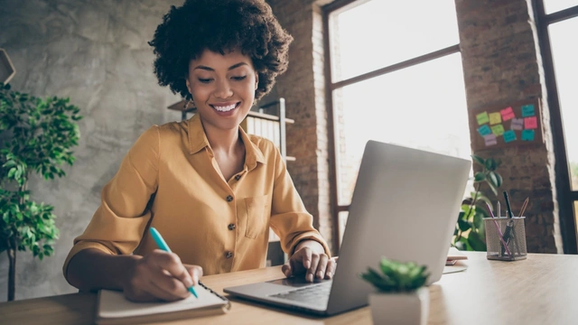 woman on laptop with notepad