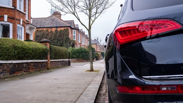 Black car parked up on residential street