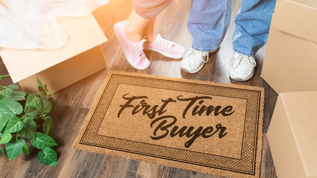 couple standing on first time buyer doormat