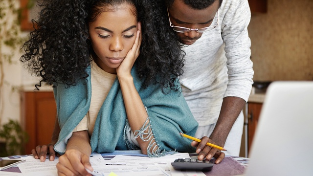 worried couple looking at bills