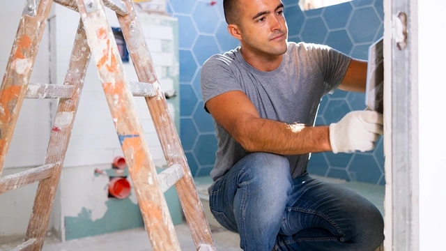 man tiling a bathroom