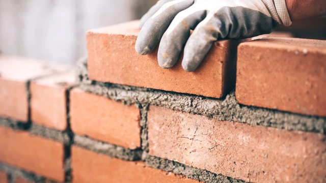 Close up of a bricklayer layering bricks on a construction site