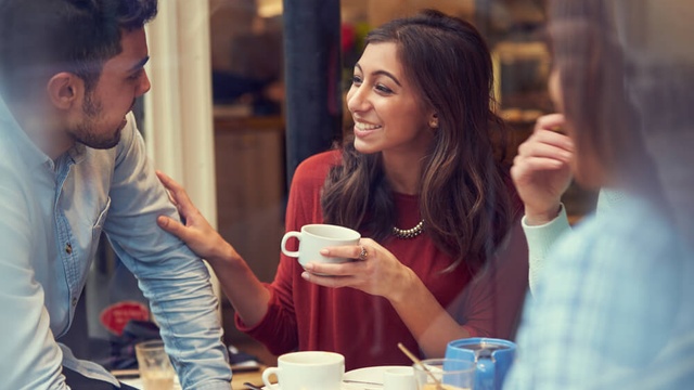 A woman enjoying a hot drink with friends.