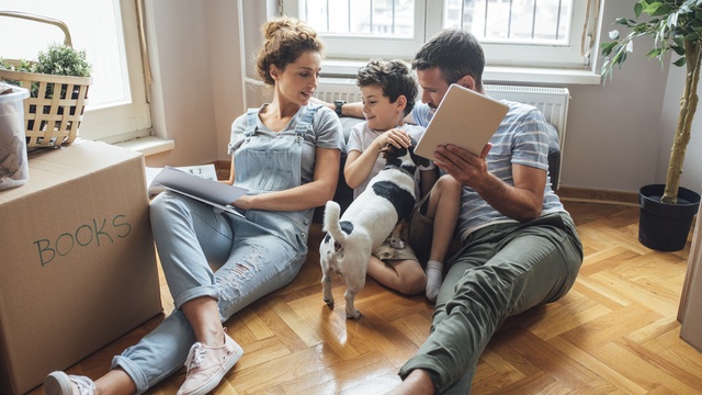 Happy family in new home sitting together on the floor