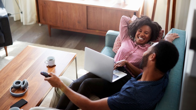 Couple in bright apartment watching TV together