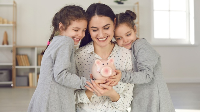 Mum holding money box with her two children.