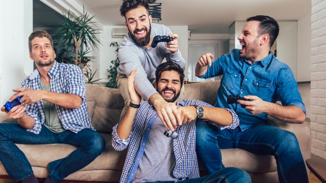 men playing video games on sofa