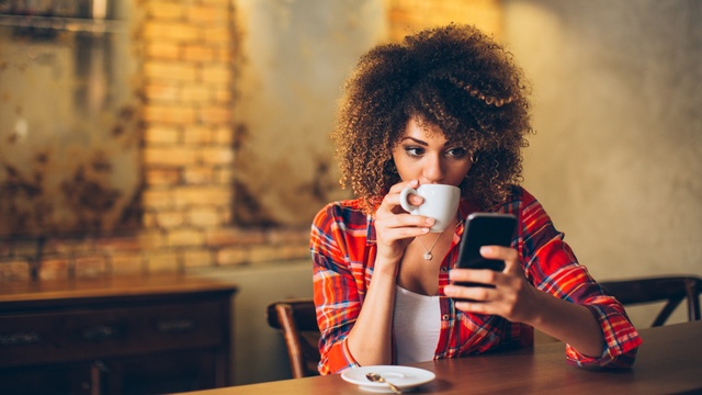 woman drinking coffee on phone