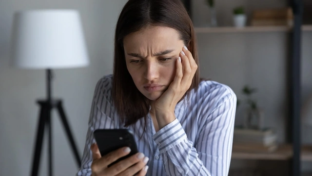 Woman looking at her smartphone, worried